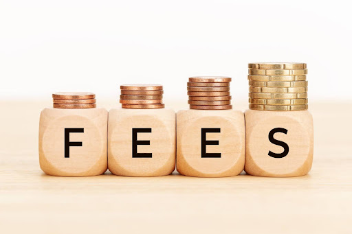 Junk Fees for Renters represented with stacks of coins on wooden blocks