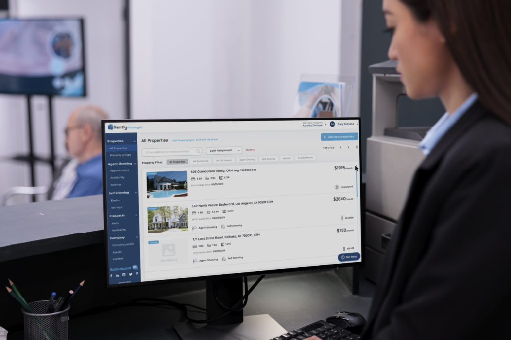 property manager at her desk looking at a desktop with the Rently Manager portal on screen